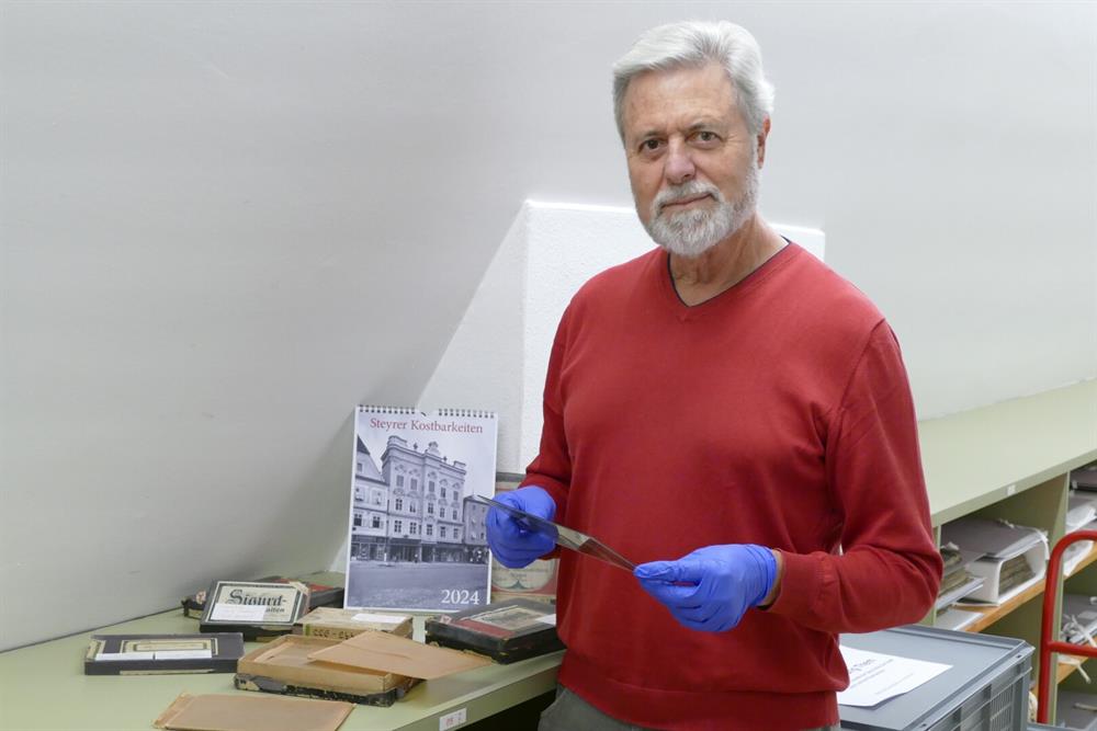 Der Vereinsobmann und frühere Stadtarchivar Dr. Raimund Ločičnik mit den Glasplatten, die für den Kalender aufwendig digitalisiert worden sind.