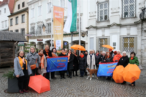Vor dem Rathaus hissen die Frauen eine orange Fahne